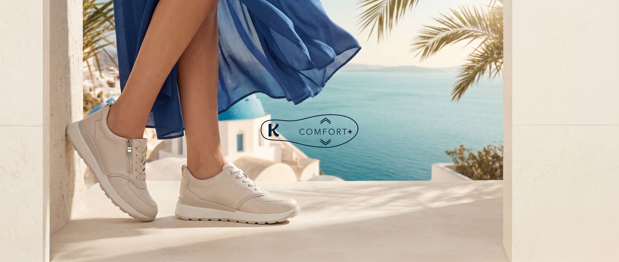 Kvinna i beige komfortskor och blå klänning framför medelhavs­havskuliss med palmer och Caprice Comfort‑logotyp.