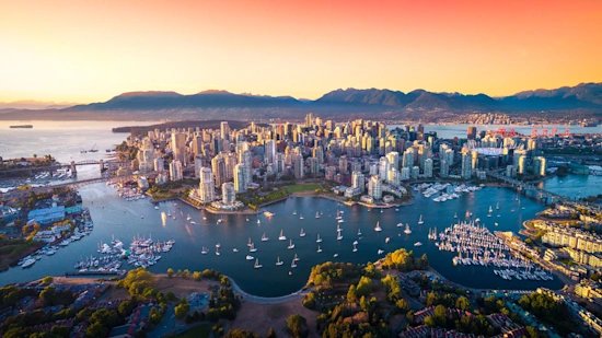 A beautiful aerial view of downtown Vancouver skyline, British Columbia (Canada) at sunset, with a lovely orange sky