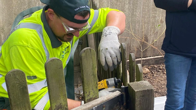 A picture of the Airfield Engineering Team at Birmingham Airport volunteering, where the team can be seen fixing a wooden gate.