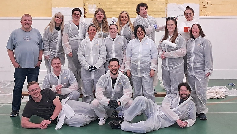 A group photo of the sustainability and communications team after a day of painting at the Birmingham Settlement Sports and Community Centre