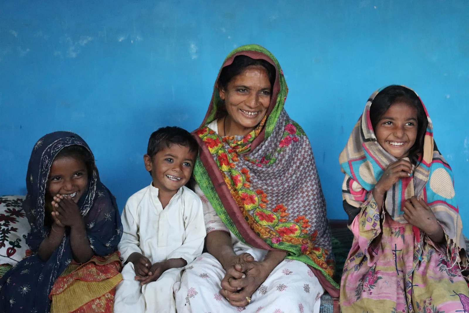 Mother with two children outside their completed Mera Apna Ghar home in rural Pakistan