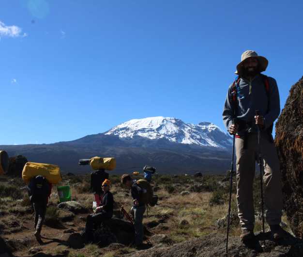 Trekkers pose with the glorious Uhuru peak in the backdrop! 