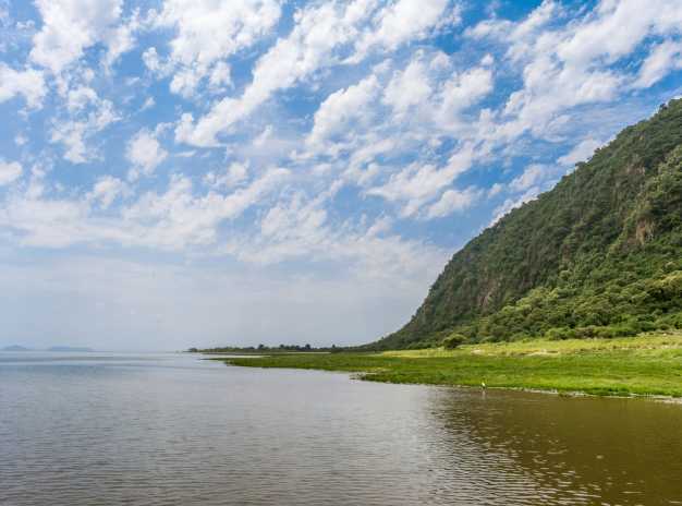 The shoreline of Lake Manyara and the escarpment of the Great Rift Valley dotted with Acacia woodlands, Lake Manyara National Park
