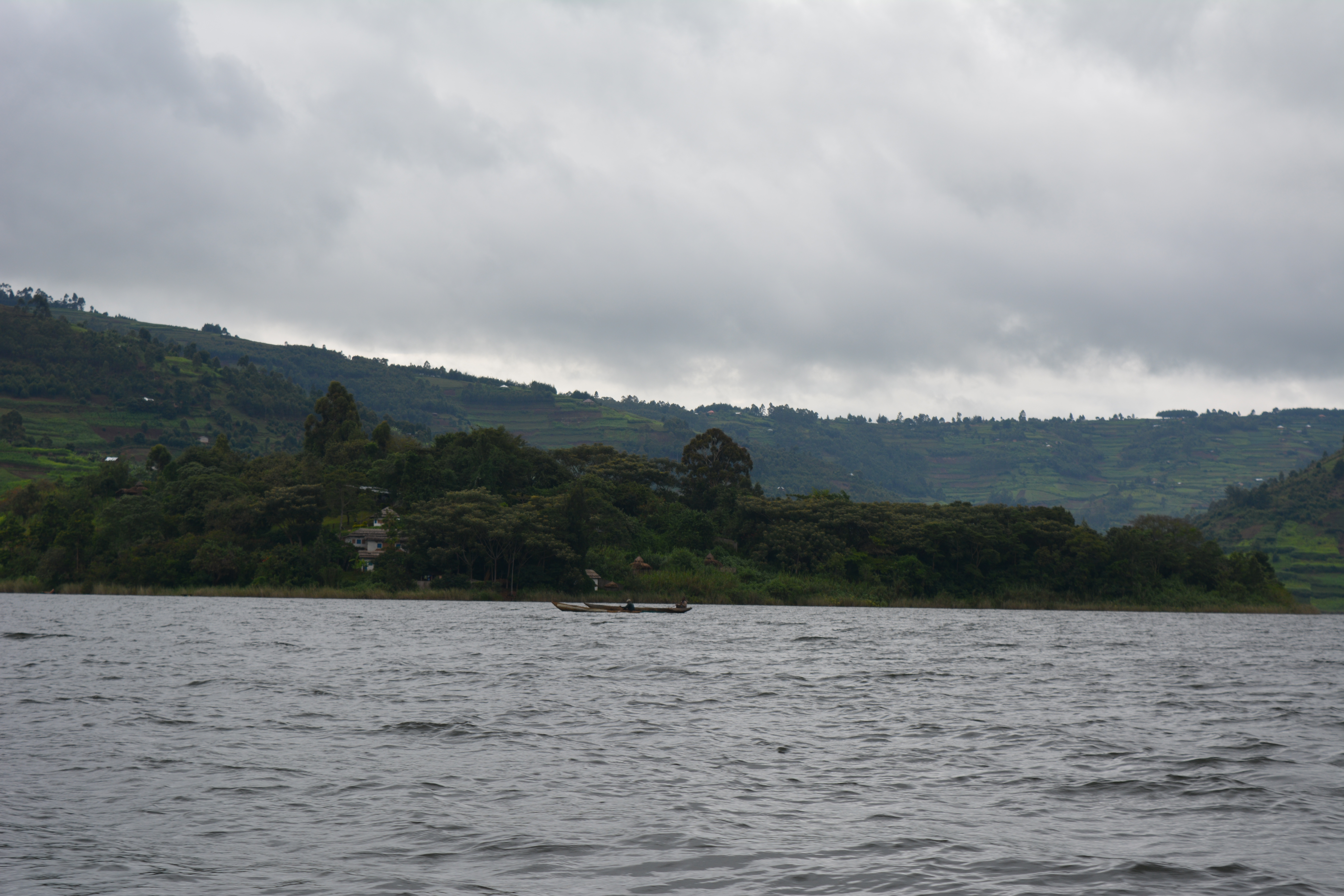 Tourists peacefully boating through the charming lake bunyoni and viewing the Uganda mountains