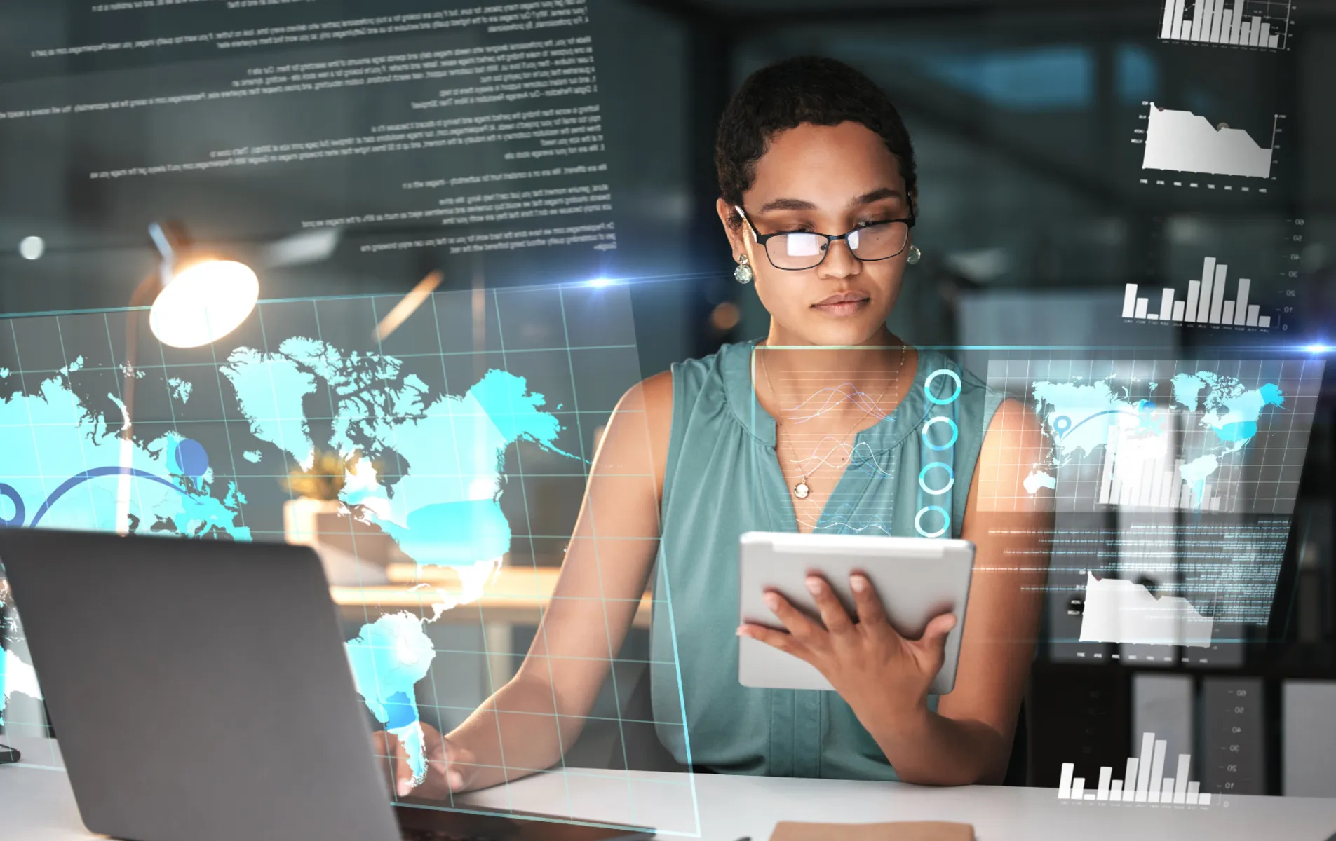 Woman with glasses holding a tablet at a desk with a laptop, surrounded by holographic global maps and data charts.