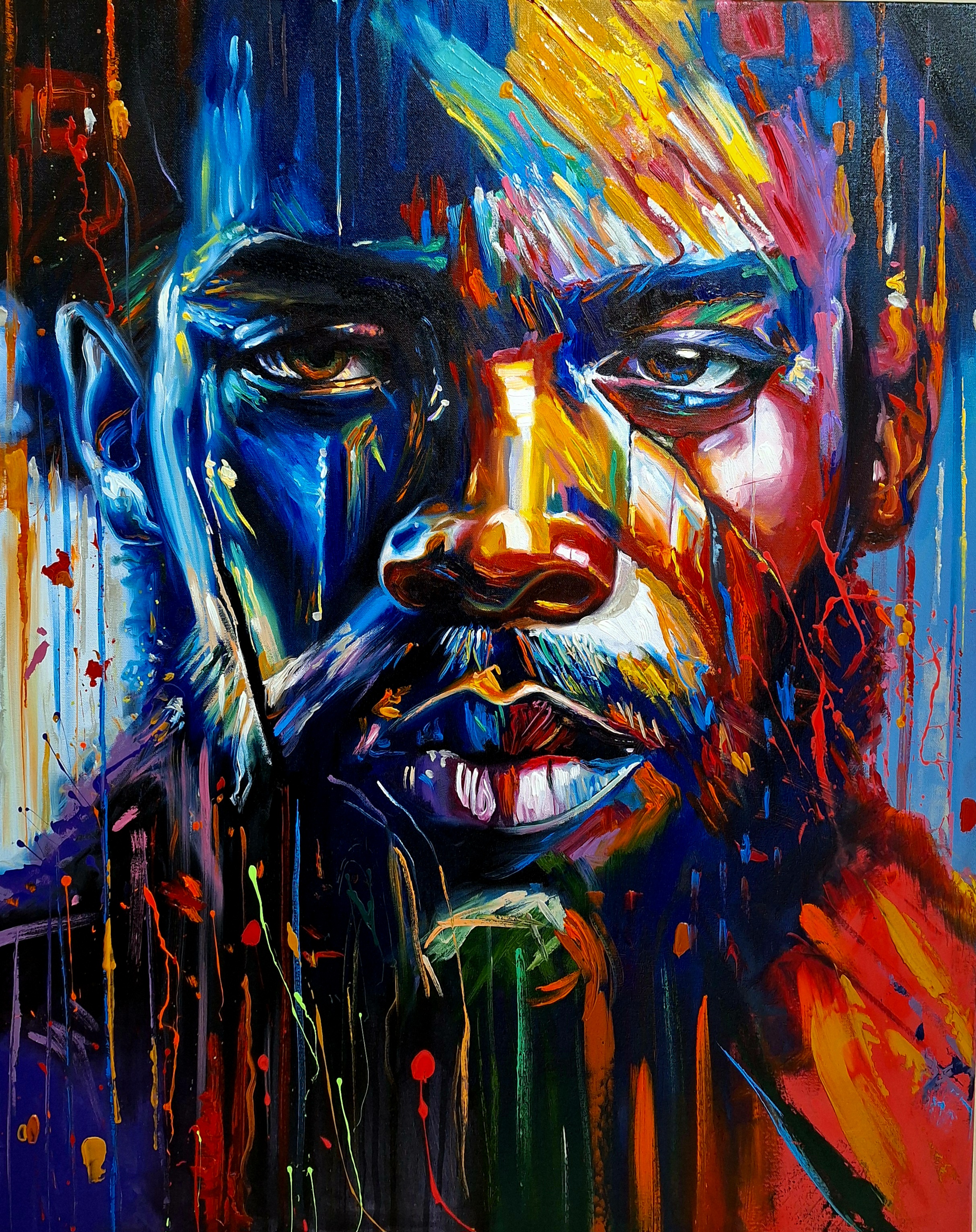 Primer plano de rostro masculino en azules, rojos y naranjas con chorreados verticales.