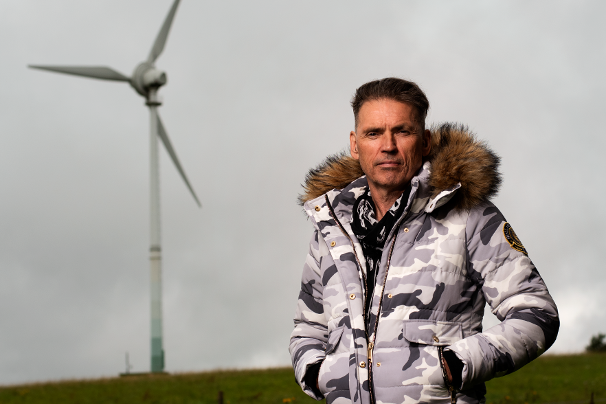 Dale Vince, founder of Skydiamond, with wind turbine in the background