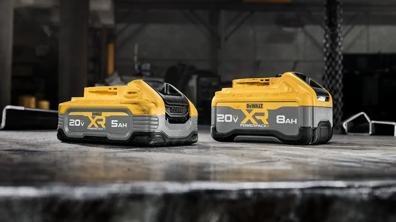 Two DeWalt 20V lithium-ion battery packs, 5AH and 8AH XR models, with yellow and black casings on workshop surface.