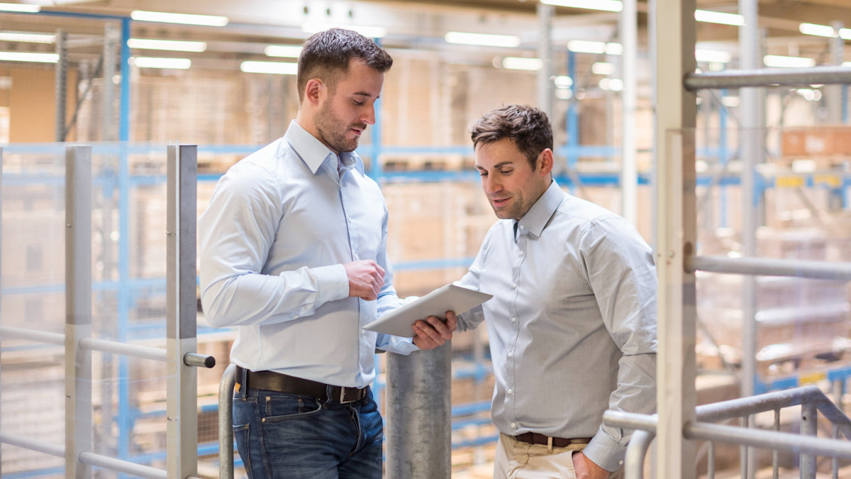 two workers looking over a tablet in the warehouse