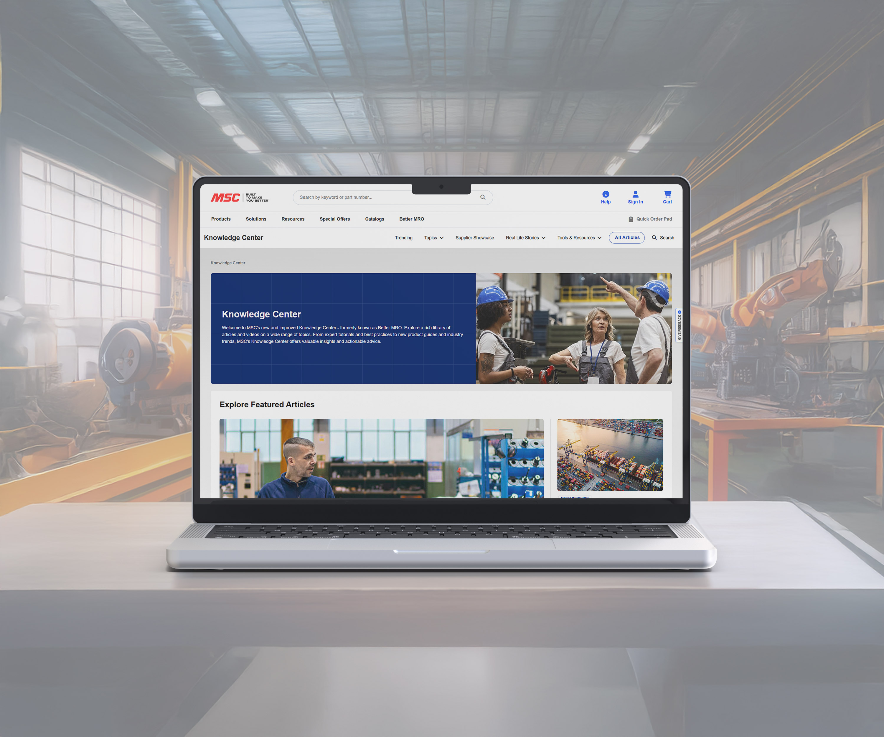 a laptop on a desk in a shop floor with screen showing Knowledge Center website