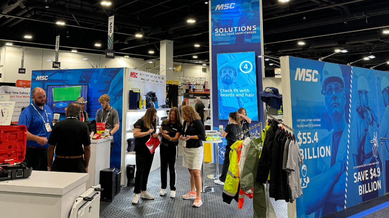 MSC trade show booth with blue branding, safety equipment displays, and attendees viewing safety solutions and apparel.
