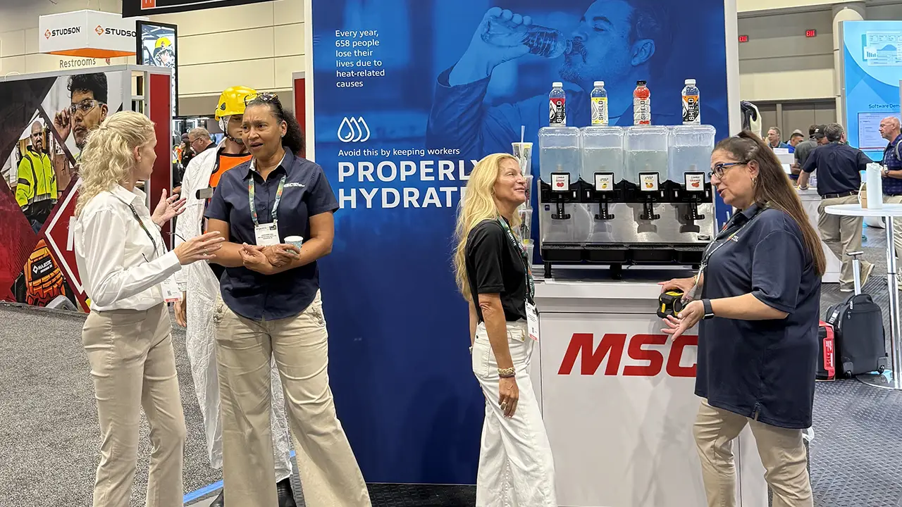 MSC trade show booth featuring worker hydration display with beverage dispensers and attendees discussing products