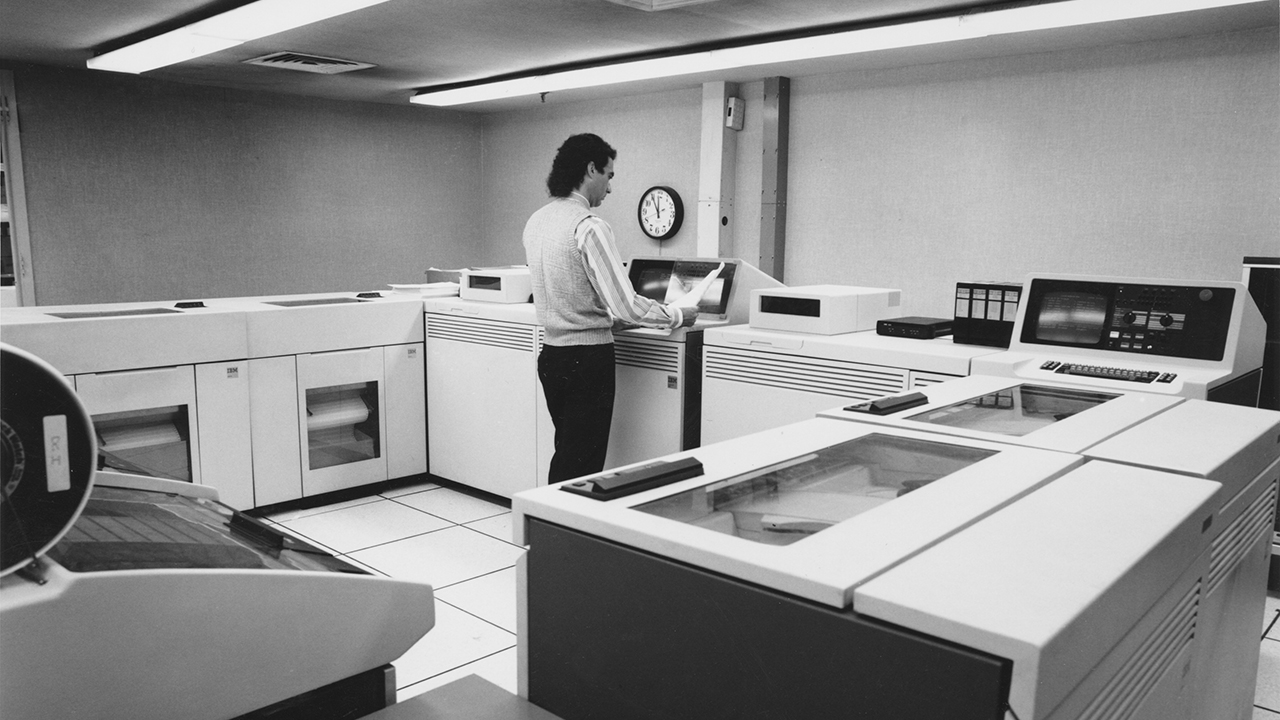 worker reading a printout of an order from computerized inventory management and order processing.
