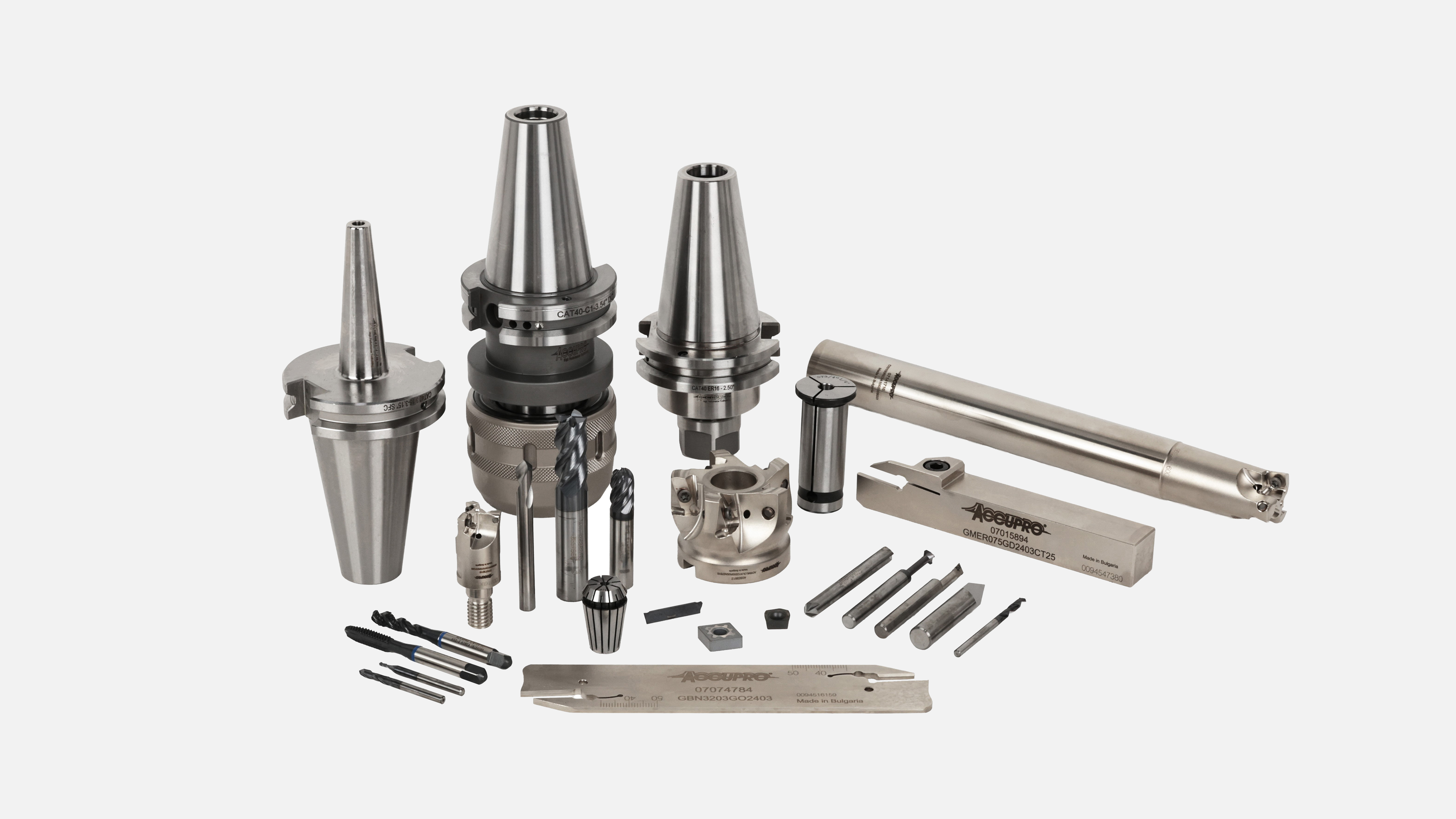 Assortment of precision metalworking tools by Accupro including tapered tool holders, drill chucks, end mills, and cutting inserts
