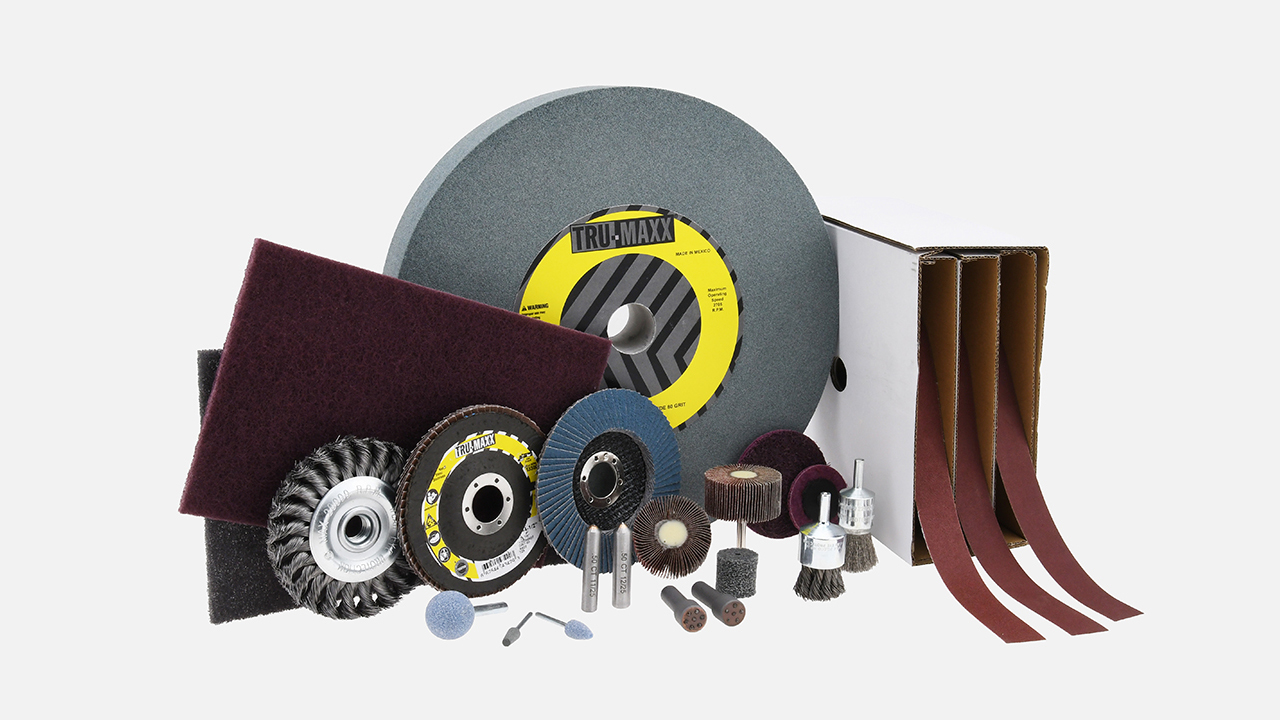 Assortment of Tru-maxx abrasive tools including grinding wheels, flap discs, wire brushes, sanding pads, and abrasive belts