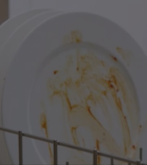 Dirty plate loaded inside dishwasher bottom rack