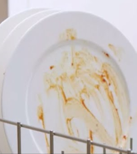 Dirty plate loaded inside dishwasher bottom rack