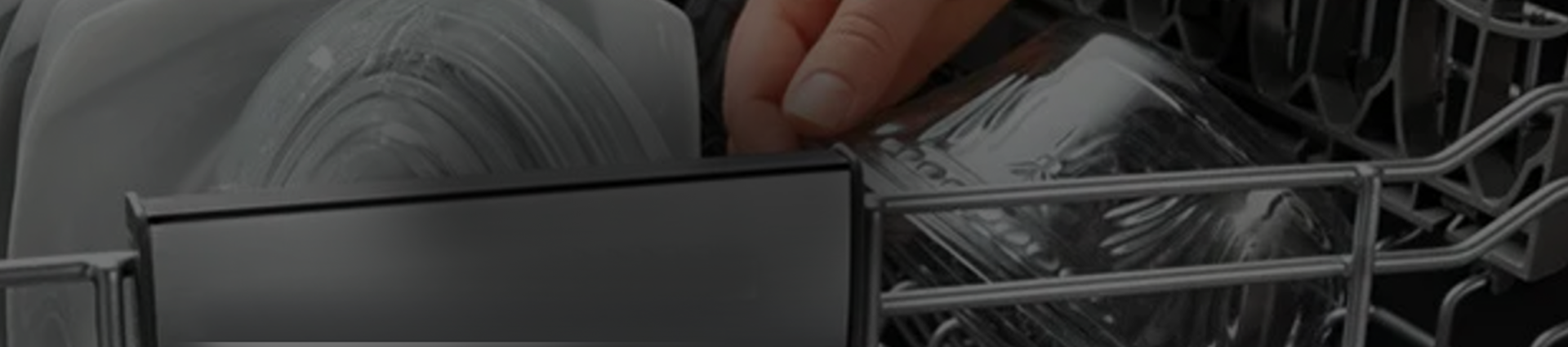 Person offloading clean glass dishware out of dishwasher