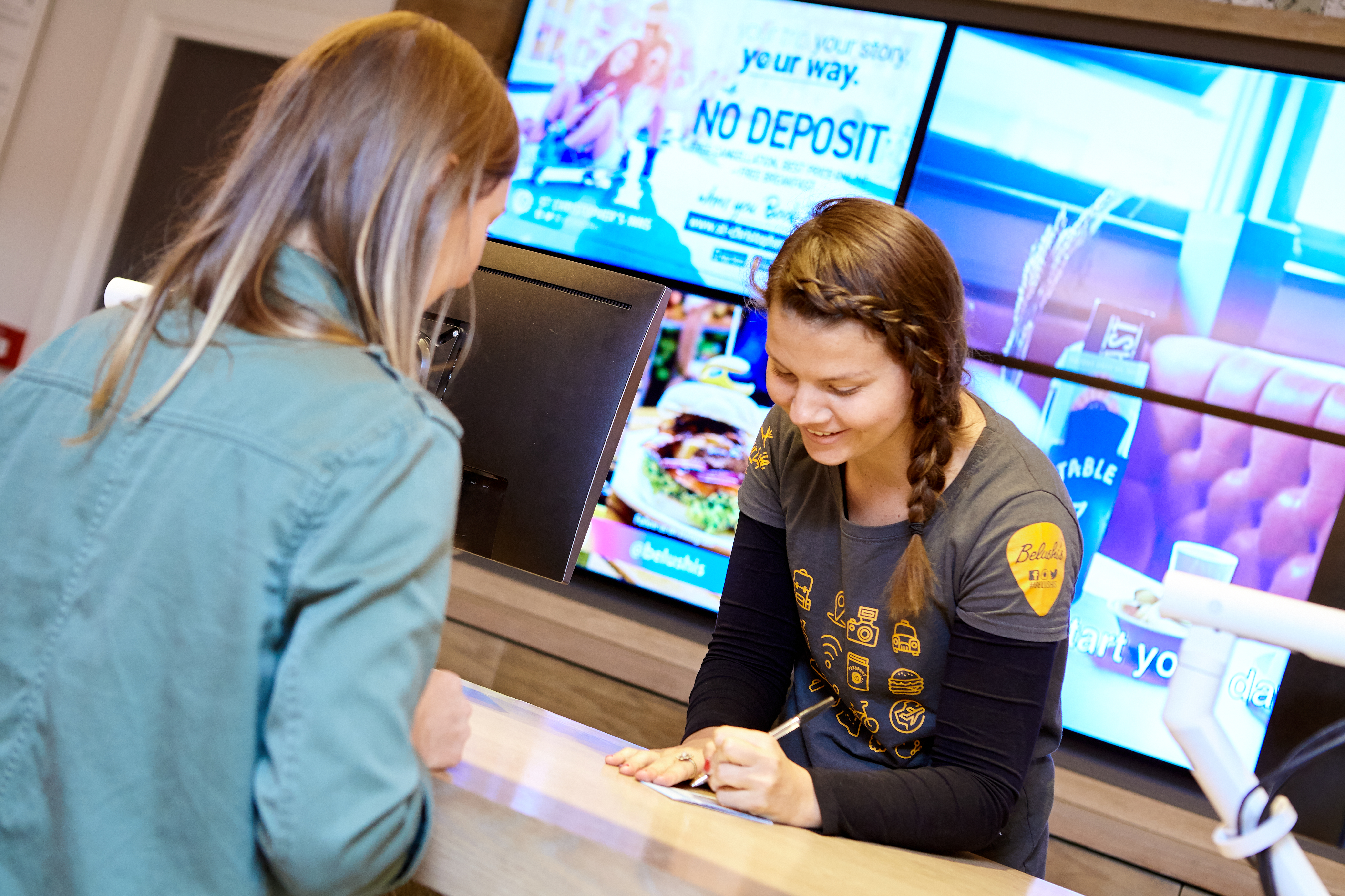 Hostel staff giving travel advice to a guest