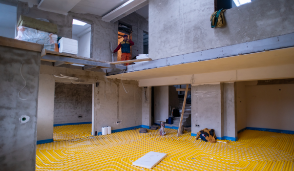 Image of installers installing an underfloor heating system in a new home