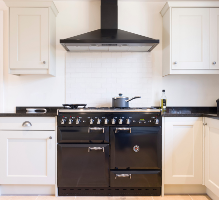 Image of a kitchen facing the cooker and extractor fan in a new build at City Plumbing.