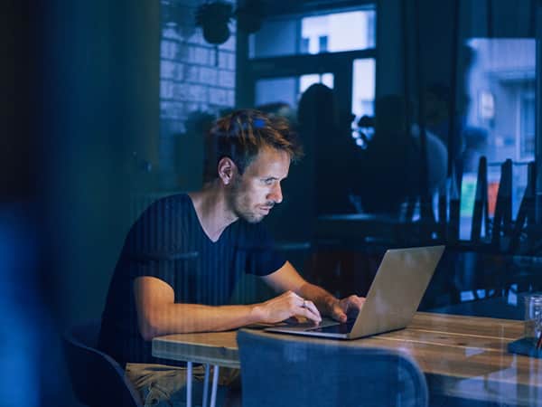 Tele2 Företag Ung man med laptop vid bord på restaurang
