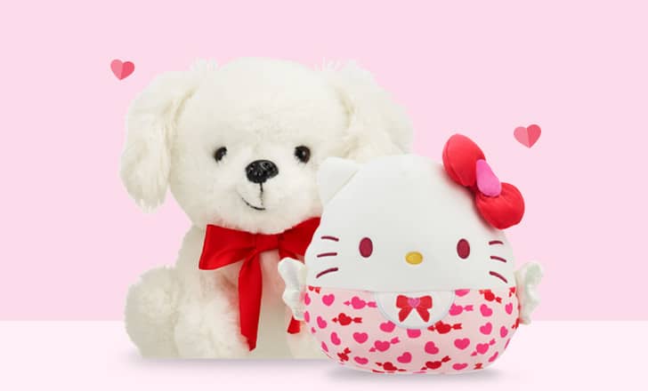 Two stuffed animals, a white puppy and a Hello Kitty.