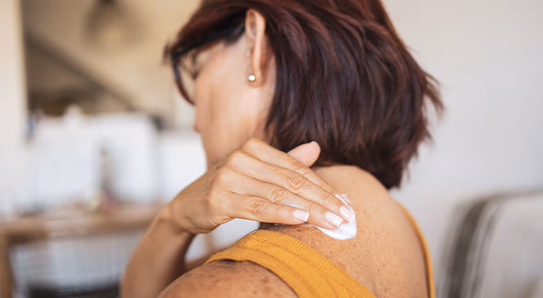 person applying lotion to their skin