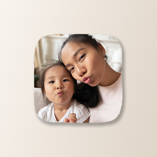 Photo of a parent and child making kiss faces as the camera on a coaster.