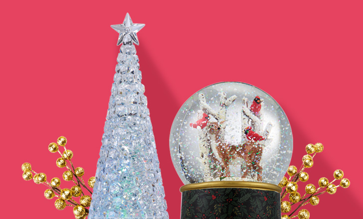 A crystal Christmas tree and a snow globe with reindeer and red cardinals.