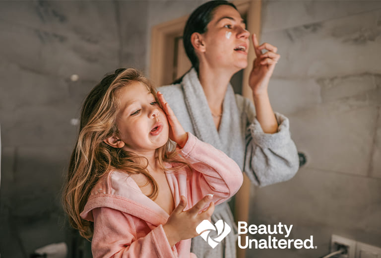 A parent and child applying lotion to their faces. Beauty Unaltered Logo