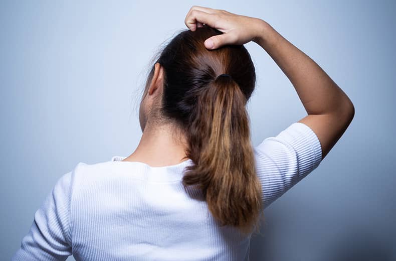 Woman scratching her head