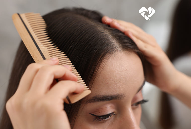 A person combing their hair. Beauty Unaltered Logo