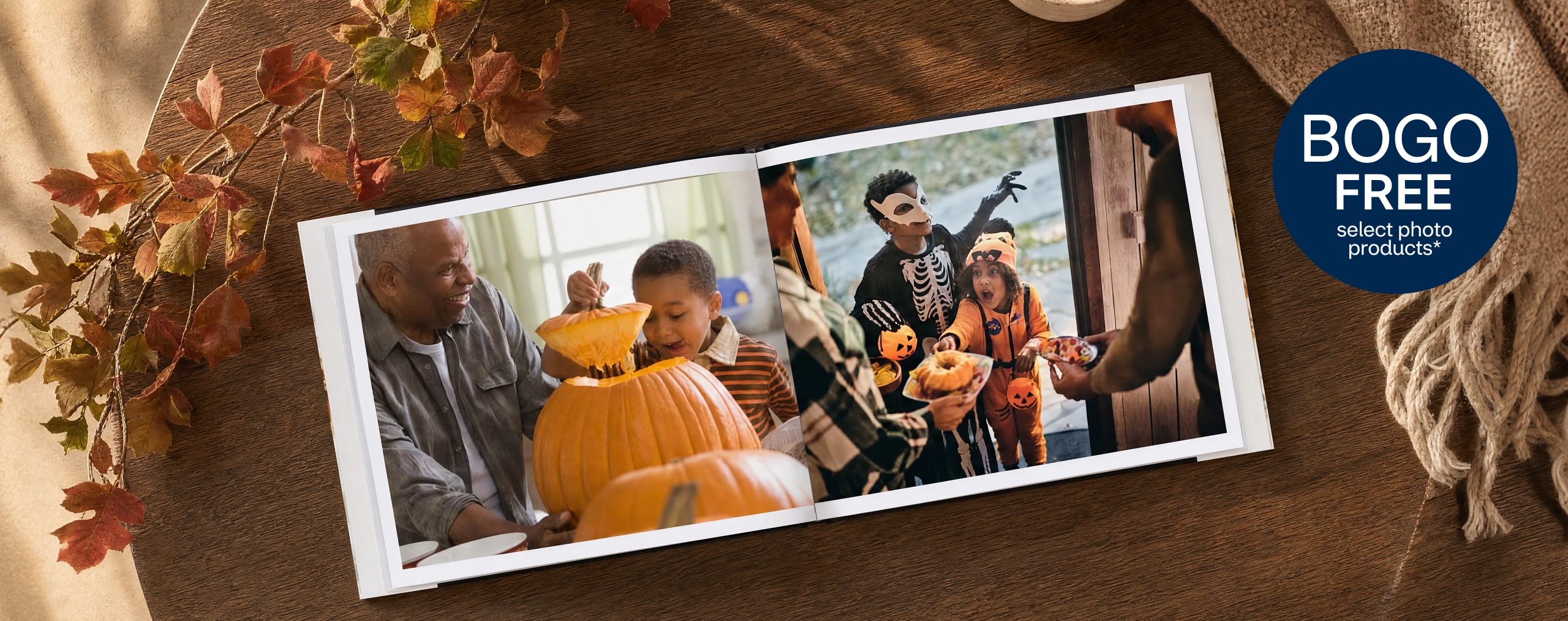 Buy 1, get 1 free. Select photo products. Halloween photo book open on a wooden surface with a table cloth and fall décor. 