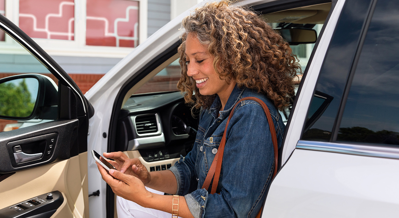 A woman gets out of her car to pick up her online order inside a CVS store.