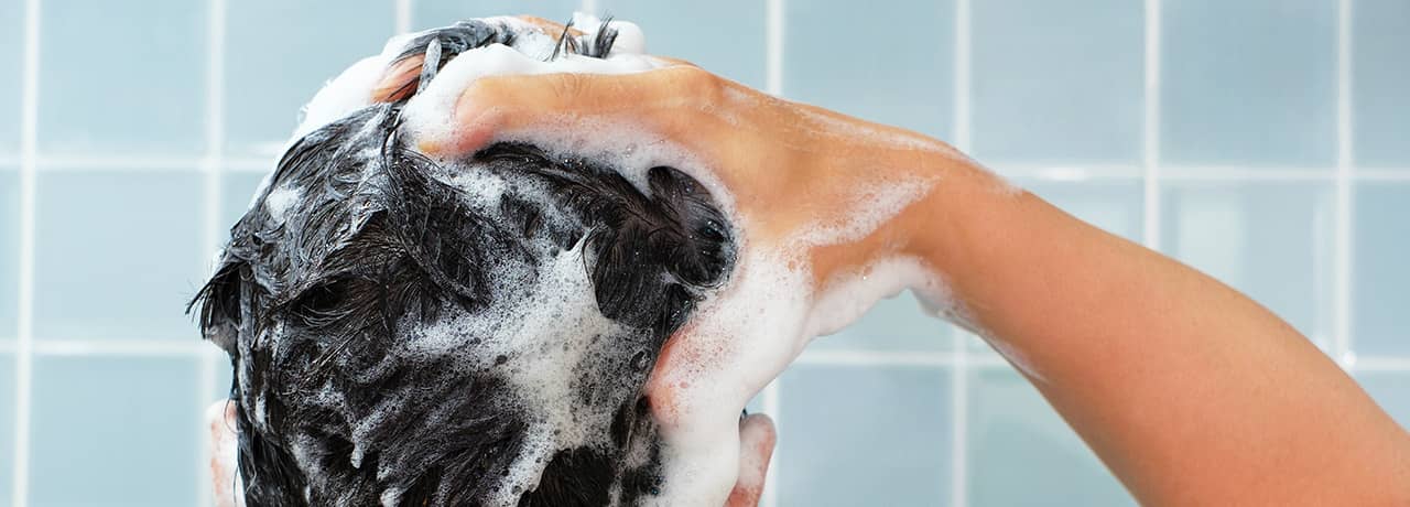 Man washing his hair in the shower.