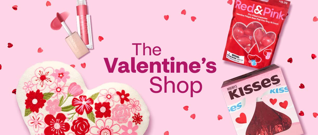 The Valentine's Shop, an embroidered heart-shaped pillow, a tube of lip color, a package of Red and Pink candy and a boxed Hershey's Kisses candy.