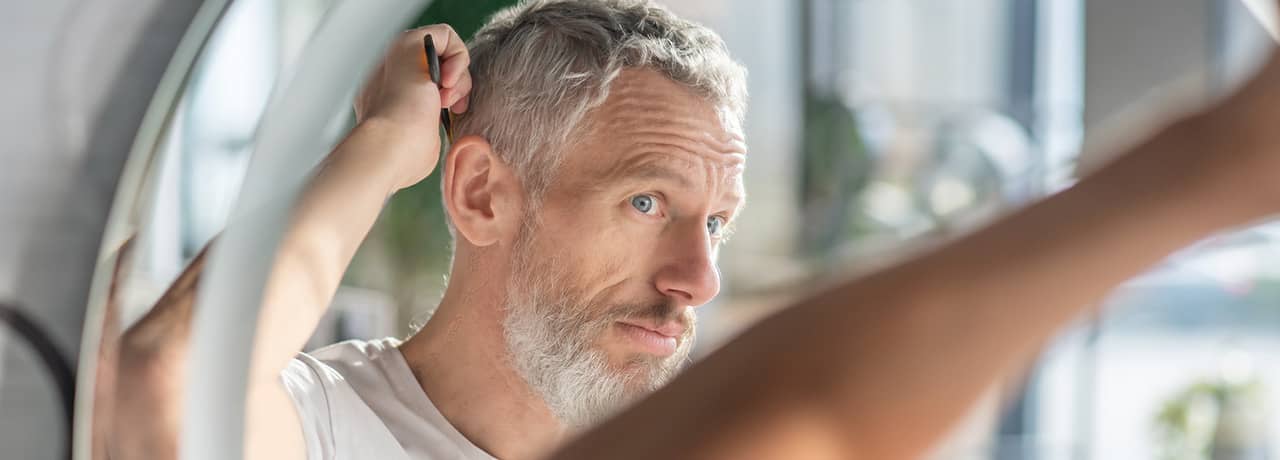 Man checking his hair in the mirror.