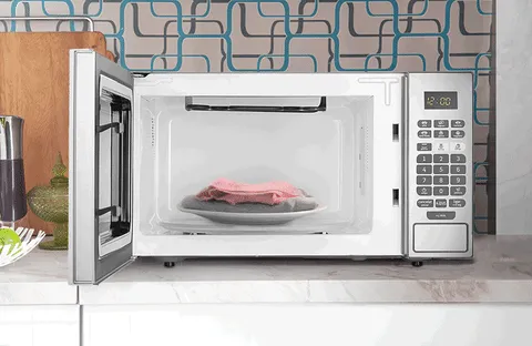 Roupas secando no micro-ondas e um sinal de proibido aparecendo por cima da imagem