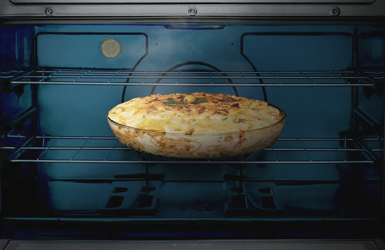 Vemos um prato dentro do forno com o grill ligado