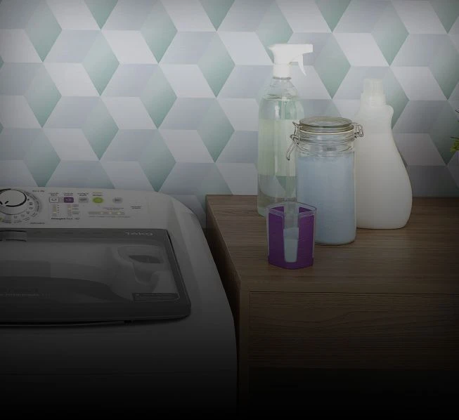 Produtos para lavagem de roupas no balcão ao lado da máquina de lavar