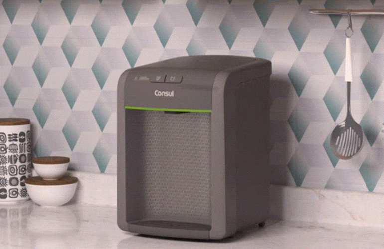 Purificador de água sobre a bancada da cozinha, com destaque para a luz que indica troca de refil