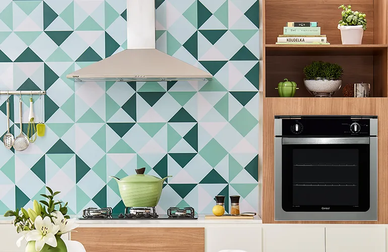 cozinha com móveis embutidos em detalhes de madeira e branco com cooktop preto, coifa de inox e forno de embutir da Consul.