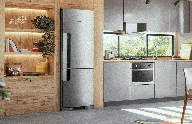 Uma geladeira com freezer embaixo sendo aberta.