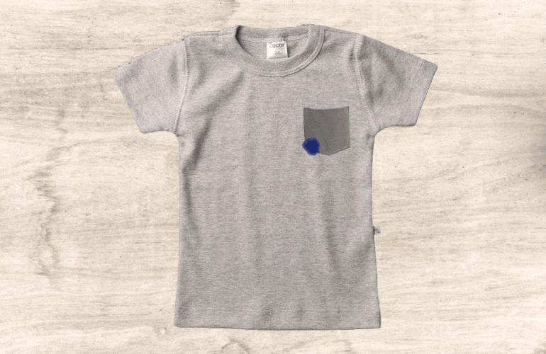 Mancha de caneta sendo removida com álcool de camiseta de criança