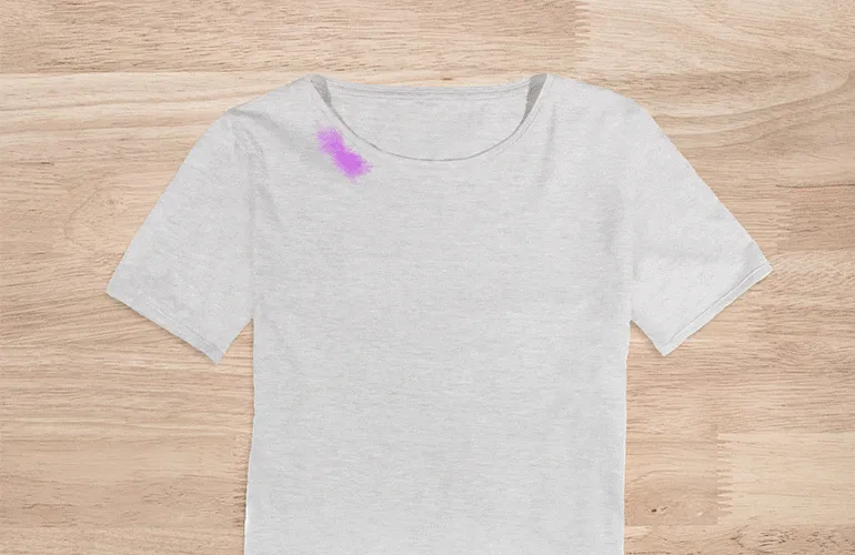 Camiseta branca manchada de maquiagem sendo limpa com algodão