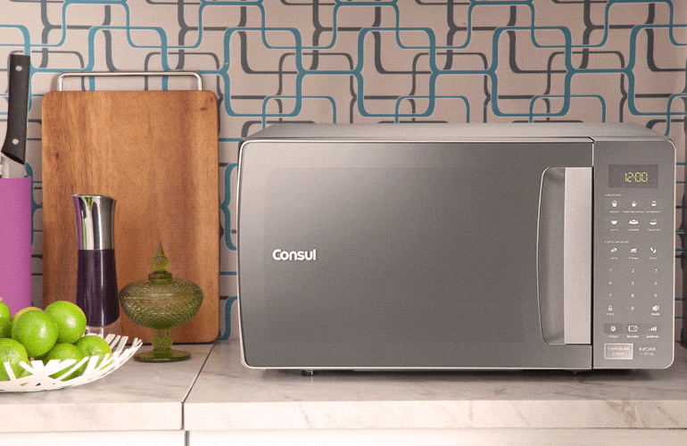 Micro-ondas sobre a bancada da cozinha com destaque para o painel de funções
