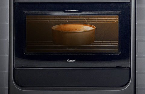 Imagem de um bolo assando em um forno. com o texto: pães e bolos precisam entrar no forno quente para crescer