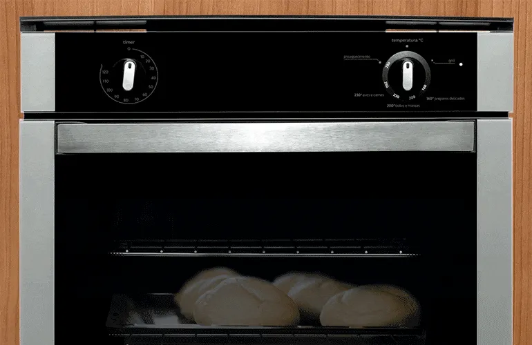 Massa de pão caseiro sendo assada em um forno de embutir.