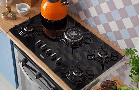 Cooktop preto da consul instalado em um balcão e de madeira ou em uma ilha branca com uma coifa de inox em cima